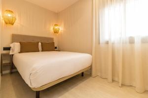 a bedroom with a large white bed and a window at MarPlana in Castelldefels