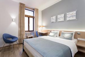 a hotel room with a bed and a blue chair at Hotel Carol in Prague