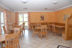 a restaurant with tables and chairs in a room at Pension Alram Hof in Eggenfelden