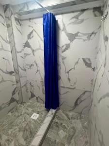 a shower with a blue curtain in a bathroom at Гостевой дом Сафар in Kapchagay