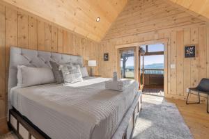 Un dormitorio con una cama grande en una habitación con paredes de madera. en Alpine Vista - Mountain Views - Blue Ridge Heights - Mountain Views, Hot Tub, Luxury Amenities in Prestigious Blue Ridge Heights, en Blue Ridge