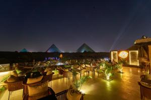- un restaurant avec des tables et des chaises la nuit dans l'établissement PANORAMA view pyramids, au Caire