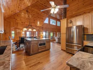 a large kitchen with wooden floors and a ceiling fan at Medley Sunset Cove - Lake Blue Ridge Cabin Rental minutes to Downtown - Blue Ridge, GA in Morganton