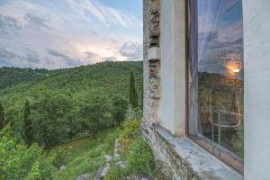 een raam van een gebouw met uitzicht op een berg bij Torre di Riosecco in Arezzo