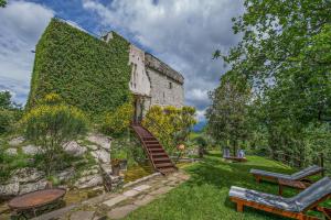 een met klimop begroeid gebouw met een houten trap in een tuin bij Torre di Riosecco in Arezzo
