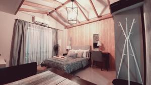 um quarto com uma cama, uma secretária e uma janela em Alpine Breeze at Crosswinds Tagaytay em Tagaytay