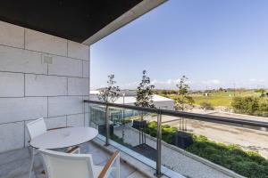 a balcony with a table and chairs and a view at Crowne Plaza - Caparica Lisbon in Costa da Caparica