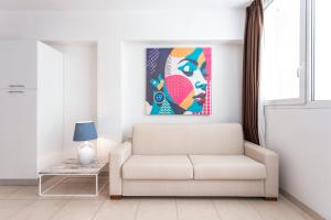 a living room with a couch and a painting on the wall at 19 Summer Suites in Santa Cesarea Terme