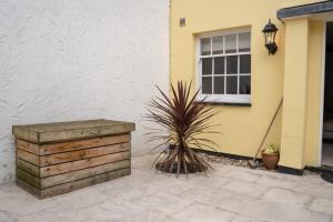 a yellow house with a wooden box next to a window at Perfectly located central Chester town house -2BR in Chester