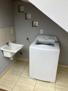 a washing machine in a bathroom with a sink at Geminado da mada casa 3 in Penha +20 photos