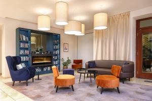 a living room with a couch and chairs and a fireplace at Hotel Carol in Prague