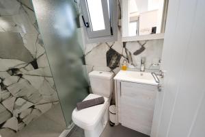 a small bathroom with a toilet and a sink at Sophie's Apartments 5 & 6 in Poros +33 photos