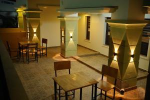 a group of tables and chairs in a room with lights at Hill Club Square in Malappuram
