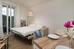 een kamer met een bed en een tafel met bloemen erop bij Belle Maison - Du Lac Apartments in Sirmione