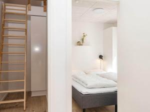 a small bedroom with a bed and a ladder at 8 person holiday home in Rømø-By Traum in Kongsmark
