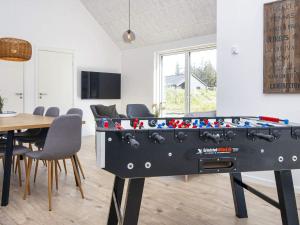 a ping pong table in a room with a table and chairs at 8 person holiday home in Rømø-By Traum in Kongsmark