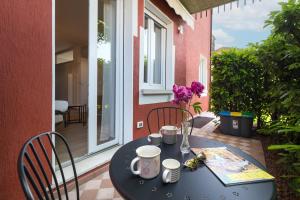 een zwarte tafel met twee stoelen en een tafel met koffiekopjes bij Belle Maison - Du Lac Apartments in Sirmione