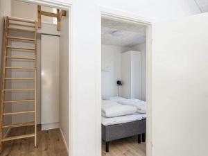 a small bedroom with a bed and a ladder at 8 person holiday home in Rømø in Kongsmark