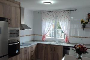 a kitchen with a sink and a window with curtains at Casa Da Praia in Lugo +35 photos