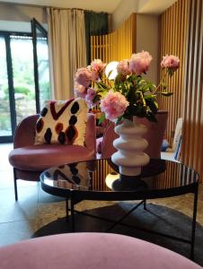 a living room with two chairs and a vase of flowers on a table at Picobello Lago in Mandello del Lario