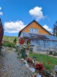 a house with a garden in front of it at Cabana Poiana Calineasa in Poiana Horea