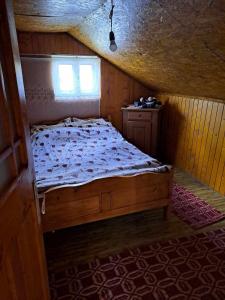a bed in a small room with a window at Cabana Poiana Calineasa in Poiana Horea