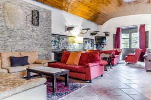 a living room with red furniture and a brick wall at Hotel Albarracín in Albarracín