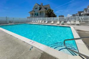 una piscina con sillas y una valla en Day at the Beach Ocean Ridge, en North Topsail Beach