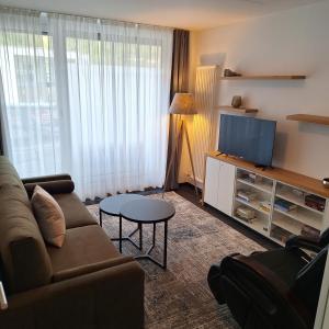 a living room with a couch and a flat screen tv at Bischoffs Hotel in Bad Urach