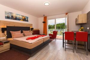 Schlafzimmer mit einem Bett, einem Tisch und einem Schreibtisch in der Unterkunft Hotel & Restaurant Hanse Kogge in Ostseebad Koserow
