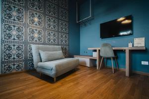 a living room with a chair and a tv on a wall at TORTE & LINI in Bologna