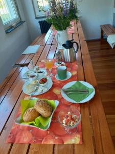 a wooden table with plates of food on it at Kleines Bahnhofshotel (Gästezimmer) in Greifenstein