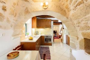 kuchnia z kamienną ścianą i łukiem w obiekcie Tzitzifes Stone Mansion w mieście Tzitzifés +37 zdjęć