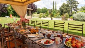 a long table with food on it in a garden at LA COLONICA 18, Emma Villas in Anghiari