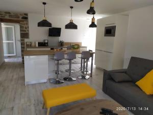 a living room with a couch and a kitchen at Chez Denise in Saint-Pol-de-Léon