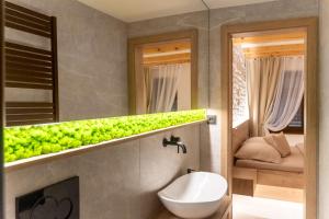 a bathroom with a sink and a toilet and a mirror at White Wolf Boutique Apartments in Olomouc