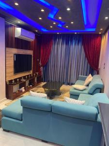 a living room with a couch and a tv at Villa in Stella Heights - North Coast in El Alamein