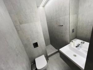 a bathroom with a white sink and a toilet at ALEM Hotel in Almaty +17 photos