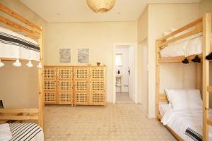 a bedroom with two bunk beds and a hallway at The Line Up in Mirleft