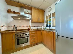 een keuken met houten kasten en een roestvrijstalen koelkast bij Casa Dream Beach in Cuevas del Almanzora