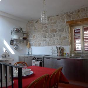 una cucina con un tavolo e un muro di pietra di The Konoba a Šibenik