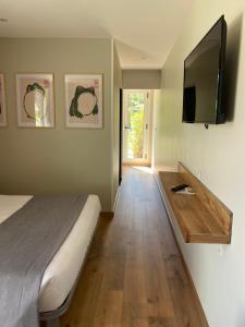 a bedroom with a bed and a flat screen tv at Les Alcyons in Le Lavandou