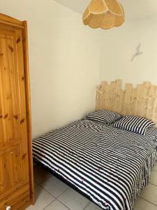 a bed with two pillows on it in a room at les fermettes de la plage in Saint-Nic