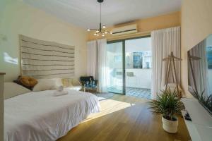 a bedroom with a white bed and a balcony at Amazing loft visionary apartment in Tel Aviv