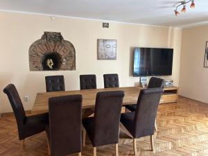Un comedor con mesa y sillas y un televisor. en Dioniss Apartment, en Sibiu
