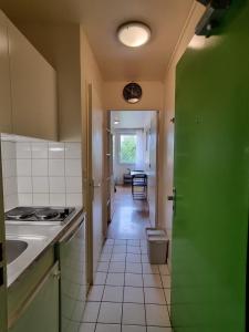 a kitchen with a green door and a hallway at Residence Erasmus in Malakoff +3 photos