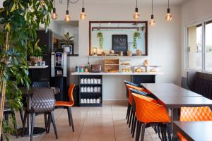 a restaurant with tables and chairs and a counter at Kyriad Belfort Centre Gare in Belfort