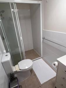 un bagno bianco con doccia e WC di Fully Furnished Modern Unit in centre of city a Emerald