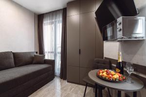 a living room with a couch and a table with a bowl of fruit at Club Marine Apart in Odesa