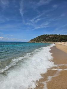 a beach with the water washing up on the shore at Villetta Mari Pintau in Geremèas
